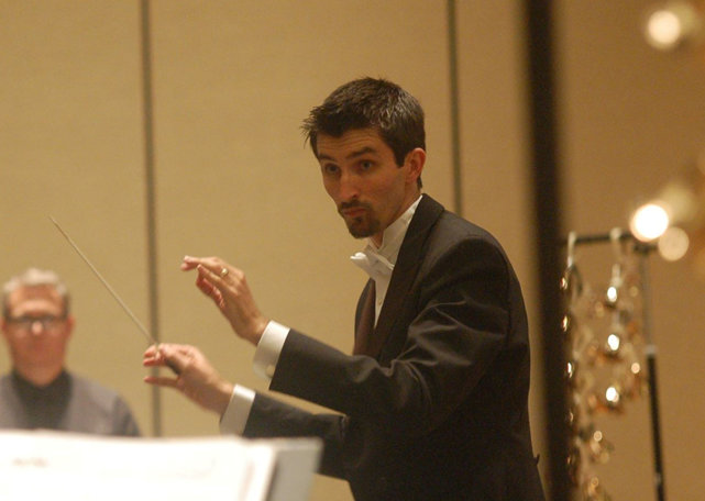 Alex Guebert conducting a handbell ensemble