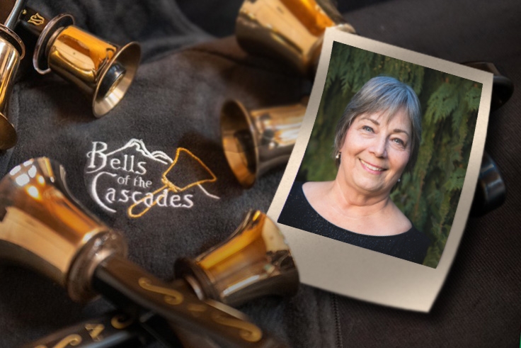 A photograph of Carolyn Bradley rests beside handbells on a table including an embroidered version of the Bells of the Cascades logo.