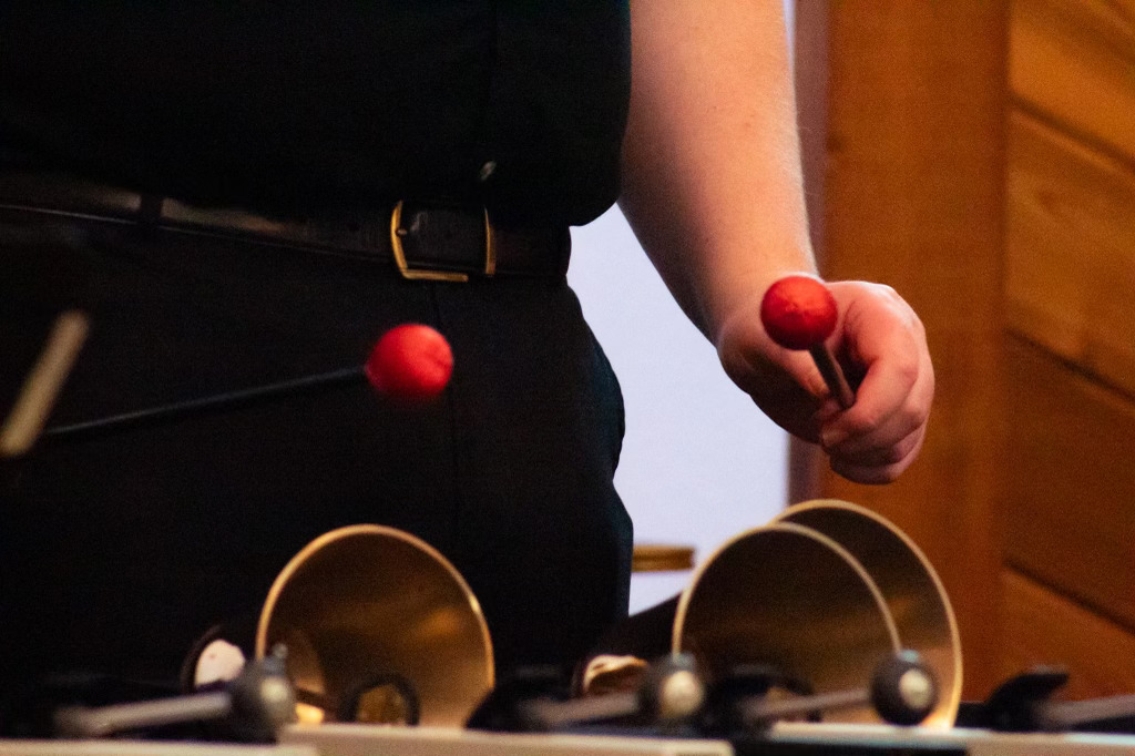 Handbell ringer malleting bells