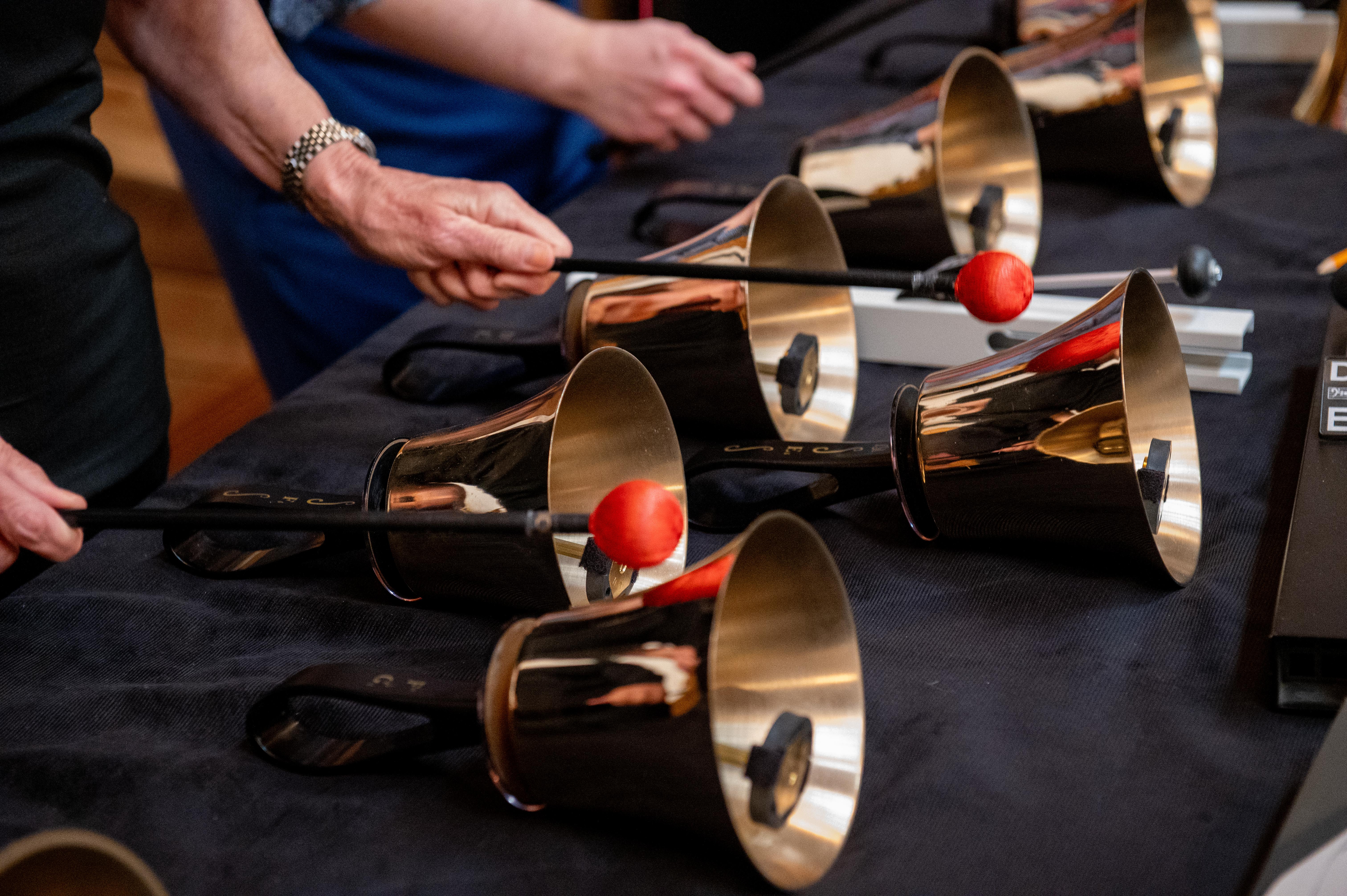 Hands using mallets to play handbells